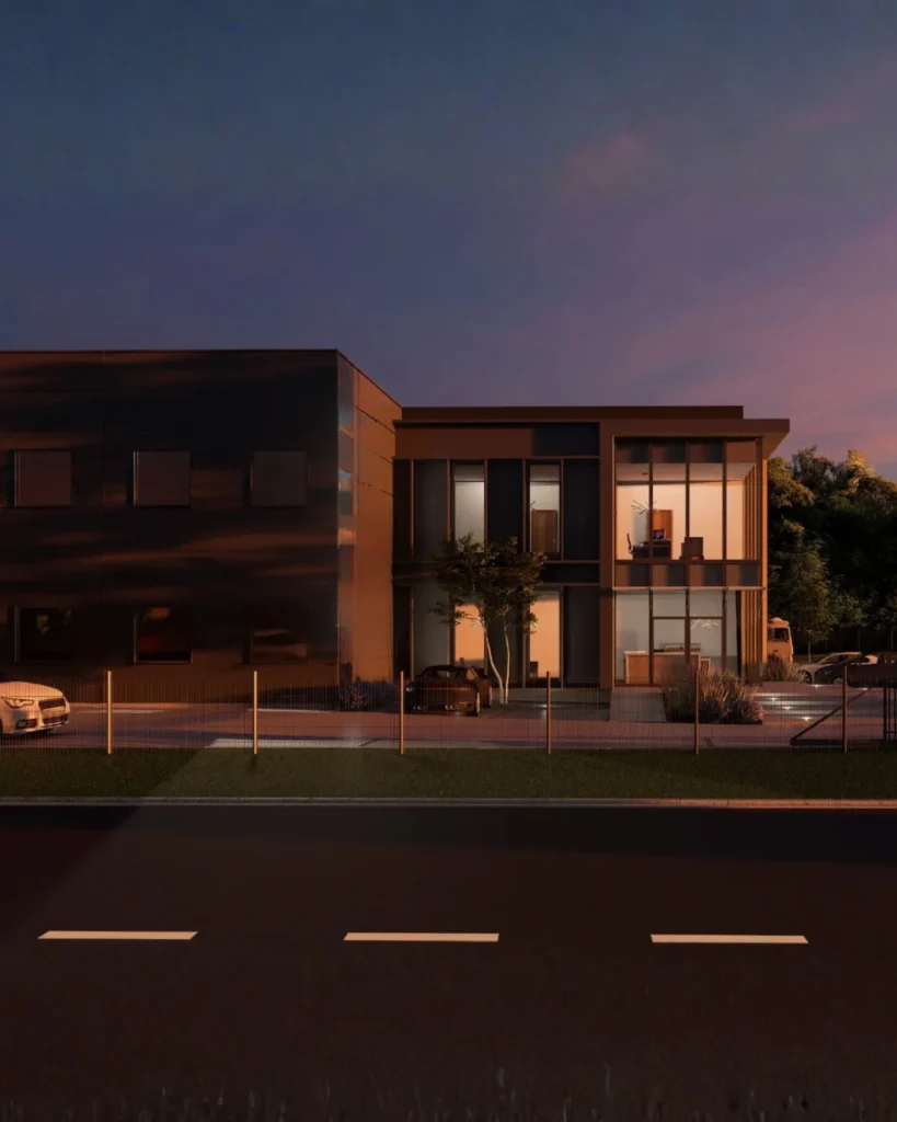Nowoczesny kompleks przemysłowo-biurowy o minimalistycznej architekturze w wieczornej aranżacji świetlnej. Widok frontowy na reprezentacyjną część biurową z dużymi przeszkleniami, podświetlonym wnętrzem oraz elegancką, ciemną elewacją budynku.